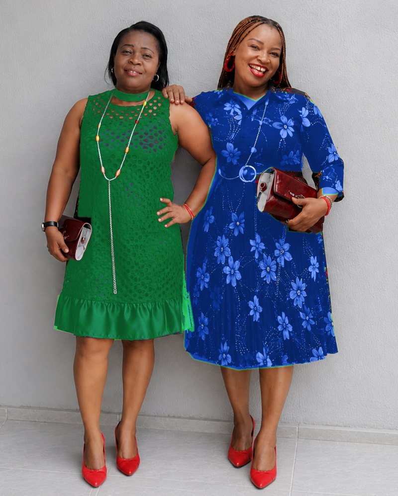 Deux femmes souriantes en robes élégantes et souliers rouges, côte à côte